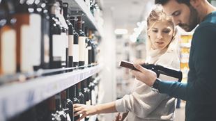 Deux personnes choisissant du vin en magasin